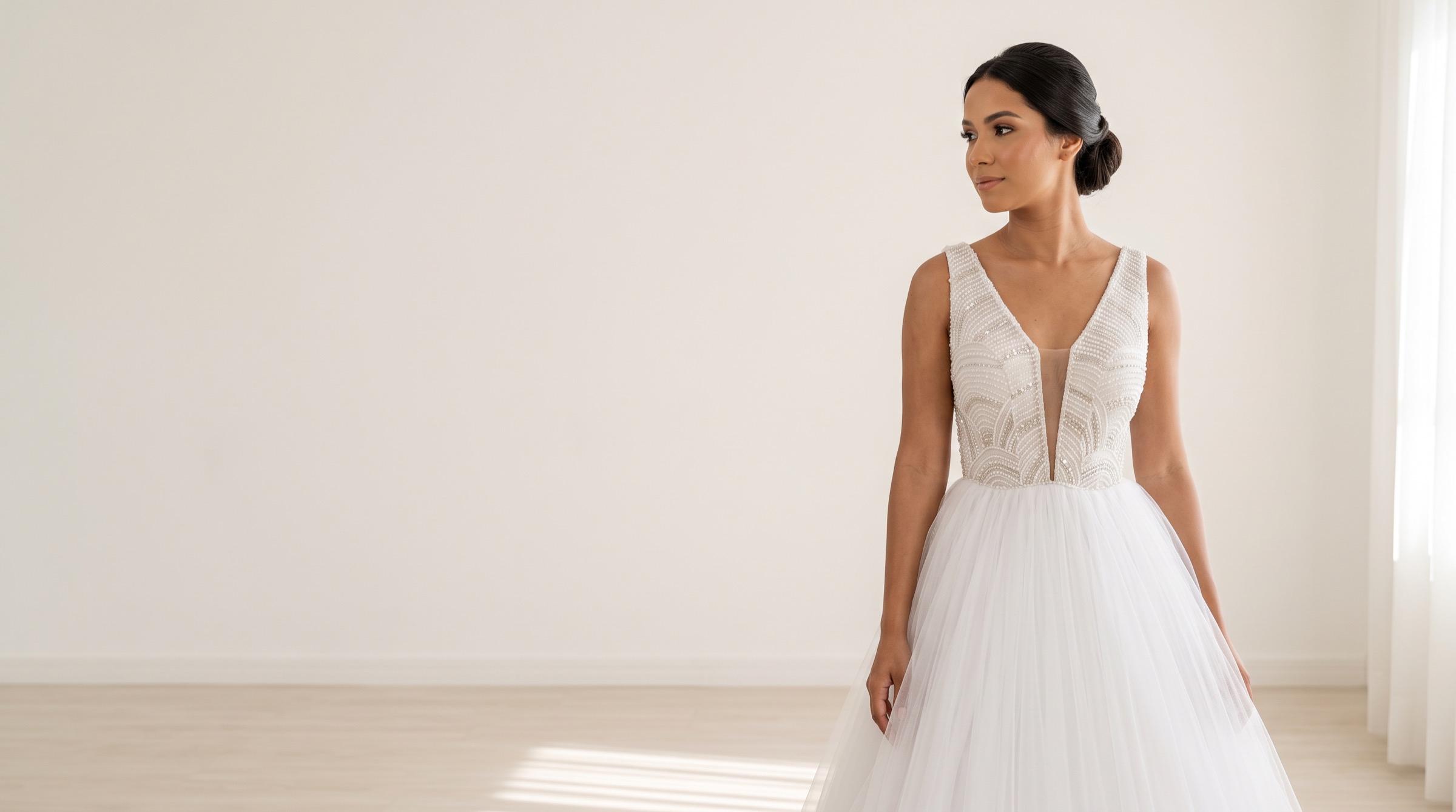 Noiva com vestido de decote em V bordado com pérolas e saia ampla de tule