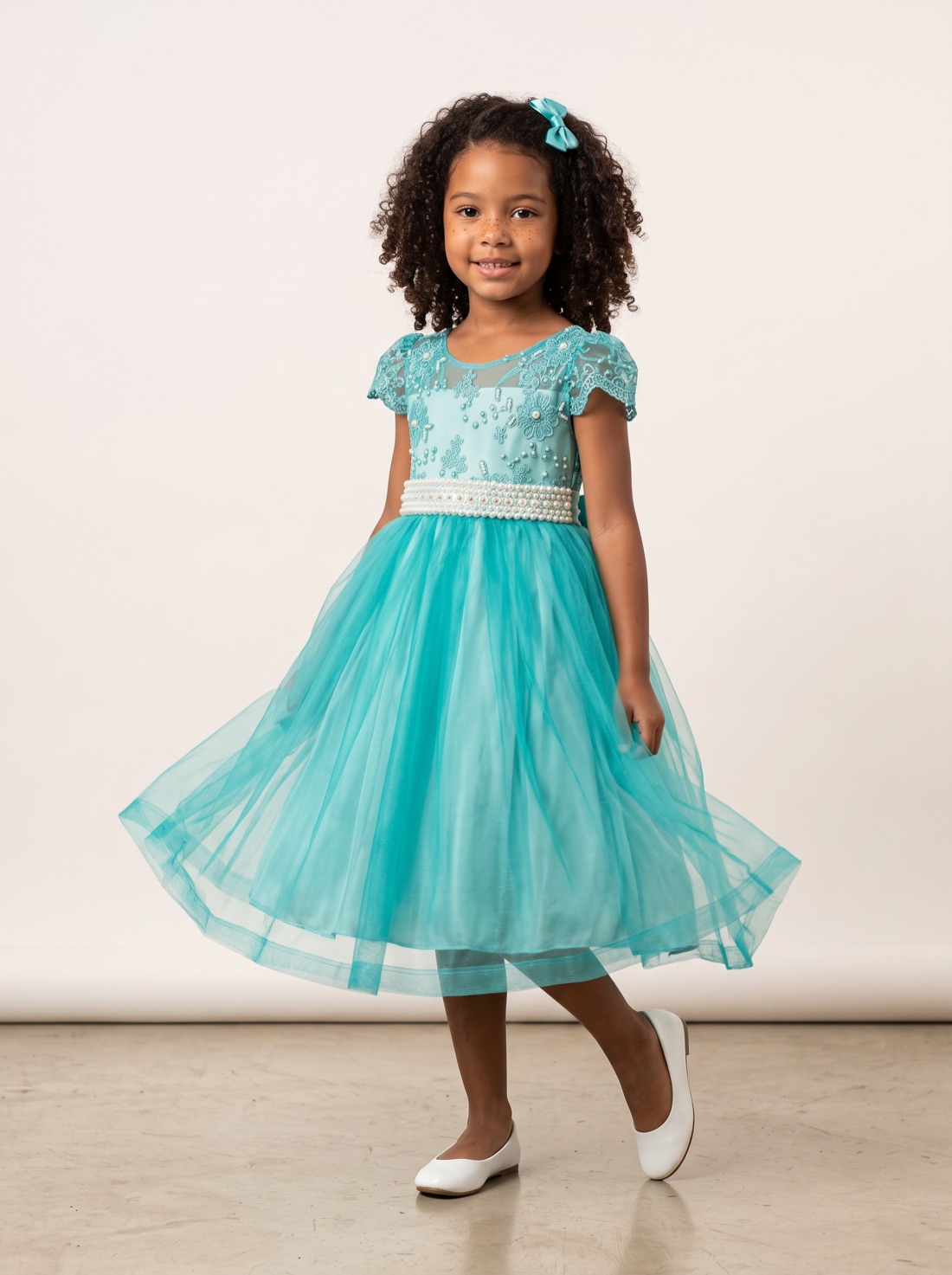 Menina com vestido turquesa de renda, pérolas e saia de tule
